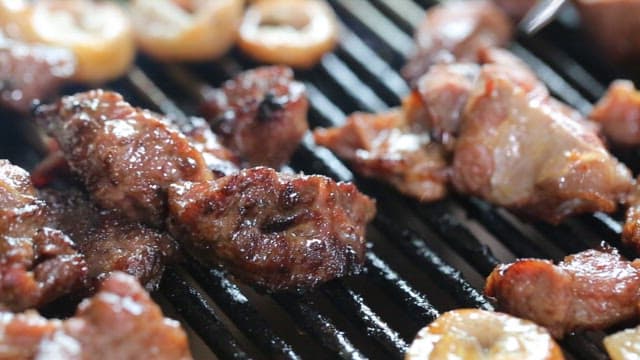 Piece of grilled pork parts, picked up with chopsticks