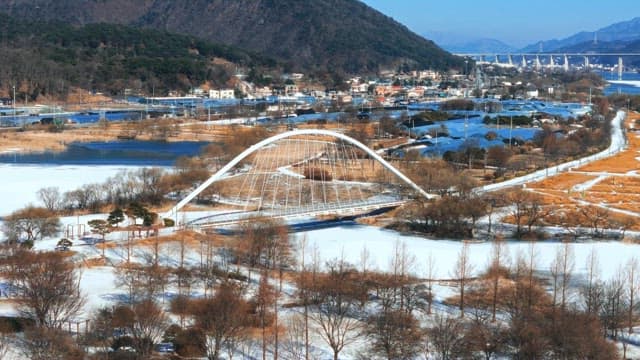 Snow-covered Park with Arched Bridge