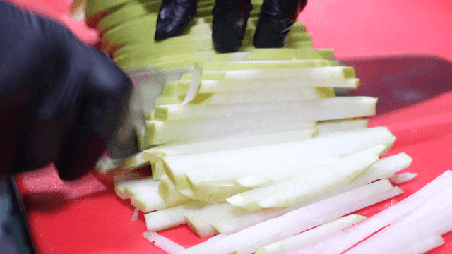 Sight of slicing radish on red cutting board