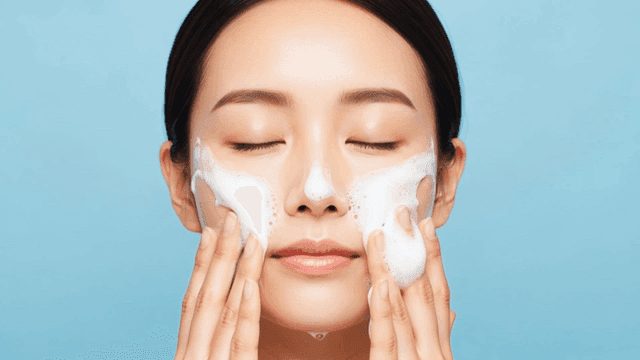 Woman gently washing her face with foam