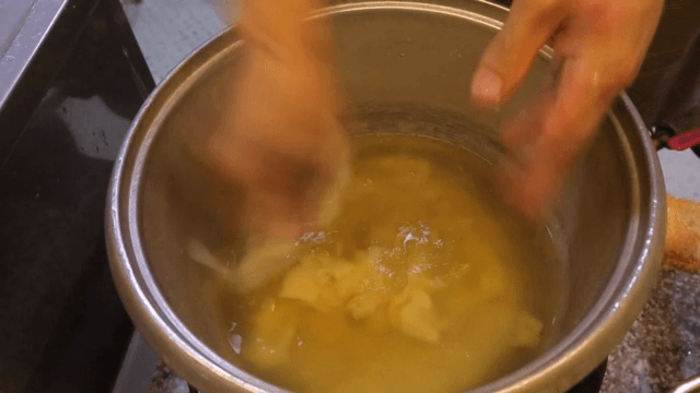 냄비에 반죽을 뜯어 넣는 손