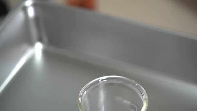 장갑을 낀 법의학자가 법과학 인공혈액을 비커에 붓는 모습