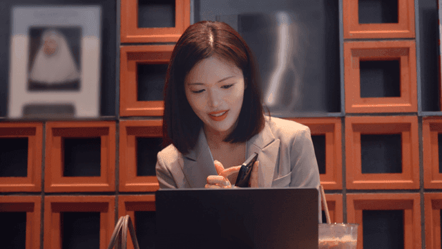 Female office worker smiling while using her cell phone