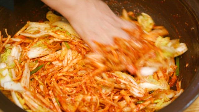 Cabbage kimchi mixed with spicy seasoning in a bowl