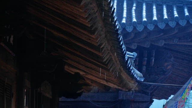 Rain falling on the wooden roof of a temple