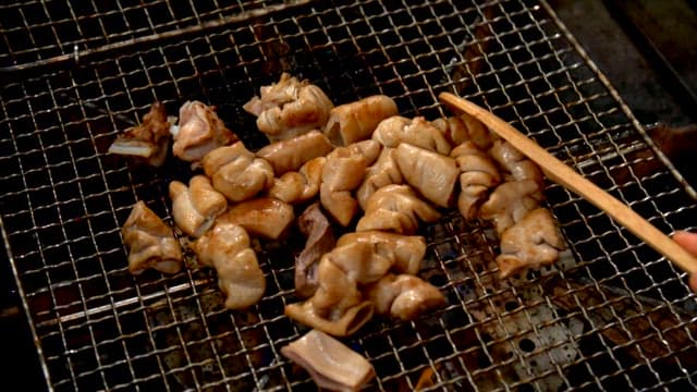 Grilling pork intestines on a grill