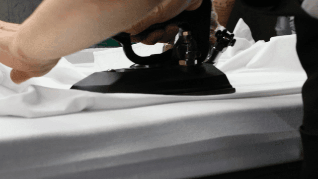 Ironing a white shirt on a table