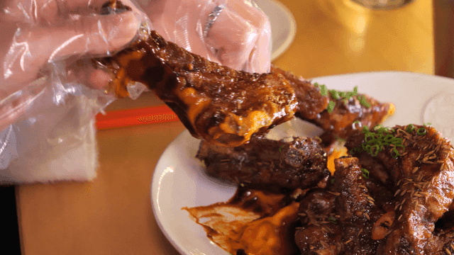 Seasoned ribs eaten with gloved hands