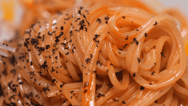 Close-up of bibimyeon topped with black seaweed flakes