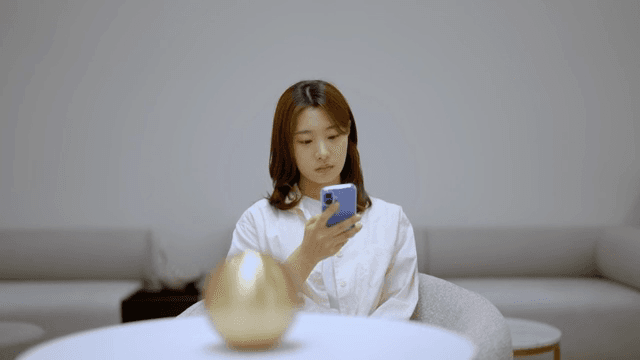 현대적인 라운지에서 스마트폰을 하며 기다리는 여성