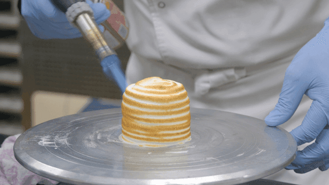 Chef caramelizing dessert with torch