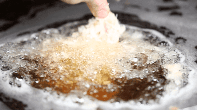 Pork cutlet going into hot oil