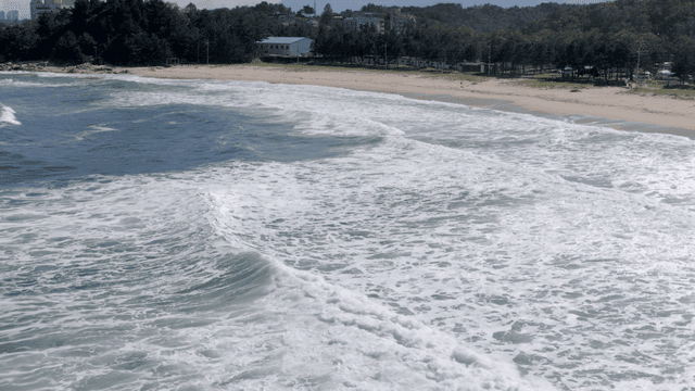 모래 해변에 부딪히는 파도