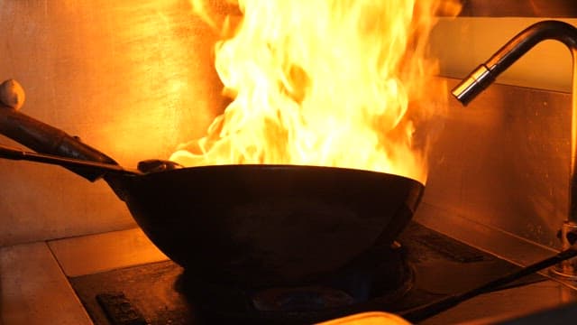 식당 주방에서 웍을 사용해 쭈꾸미를 조리하는 요리사