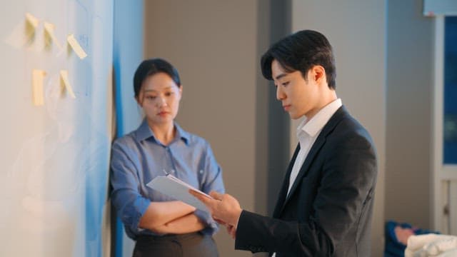 Two colleagues discussing at a whiteboard