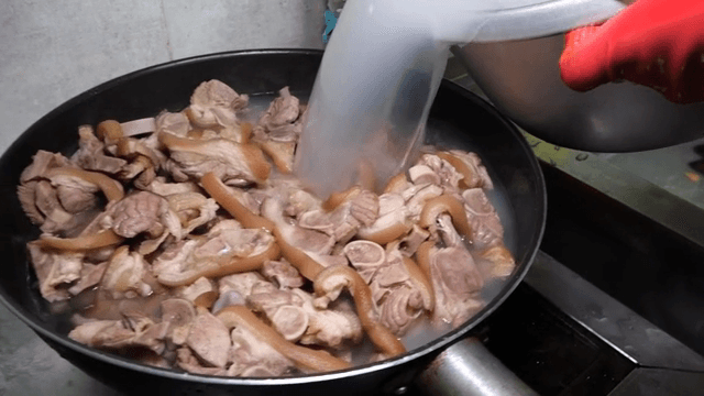 주방에서 족발에 육수 붓기