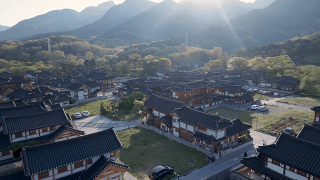 태양 아래 산으로 둘러싸인 전통 한옥 마을