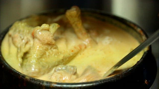 Duck soup mixing seasoning with a ladle