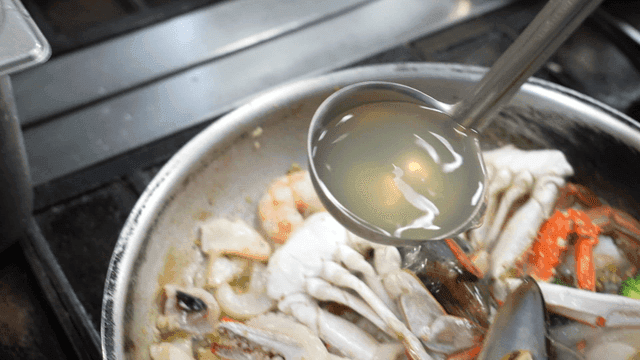 Seafood being cooked with broth
