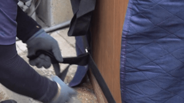 가구에 스트랩을 고정하는 사람