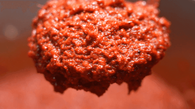 Red chili paste being stirred in a pot