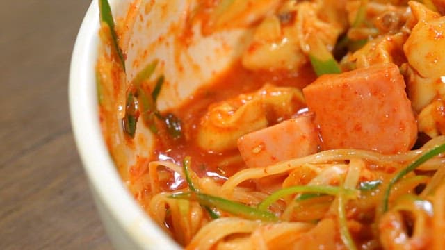 그릇에 비벼지는 햄과 파채가 들어간 쫄면