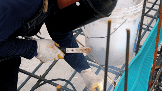 건설 현장에서 금속 막대를 용접하는 작업자