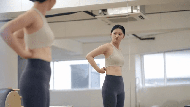 Woman checking her body while looking in the mirror