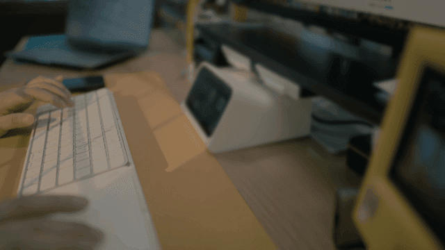 Hands typing on keyboard in front of monitor