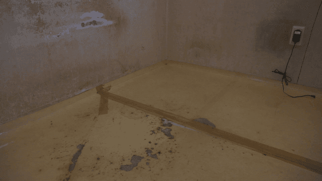 벽과 바닥이 손상된 빈 방