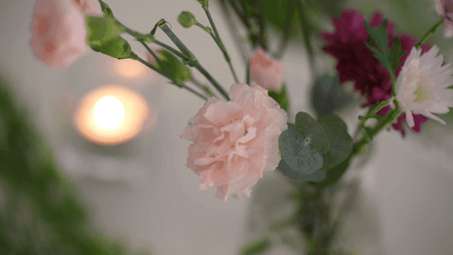 Vase of flowers with a candle