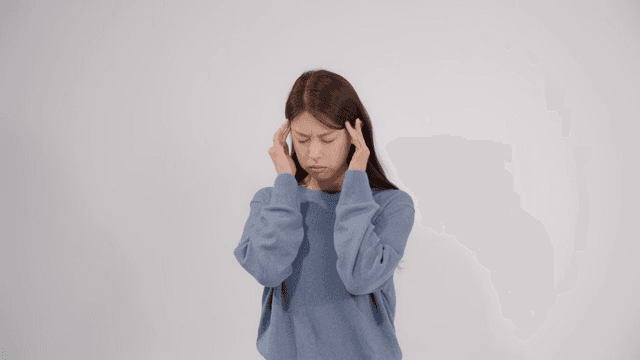 Woman holding her head with feeling headache and discomfort