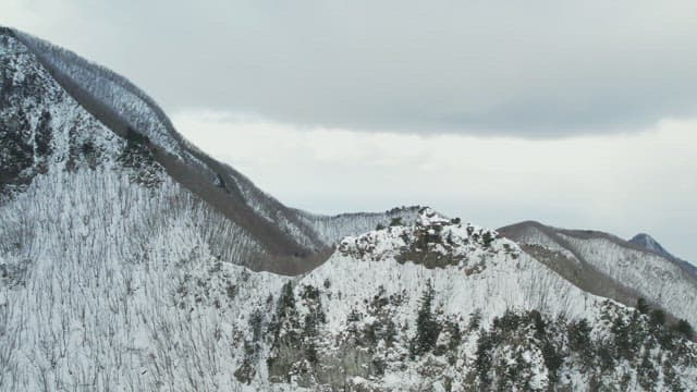 Snowy Mountain Peaks under Cloudy Sky