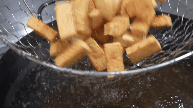 Net to scoop out golden tofu fried in hot oil