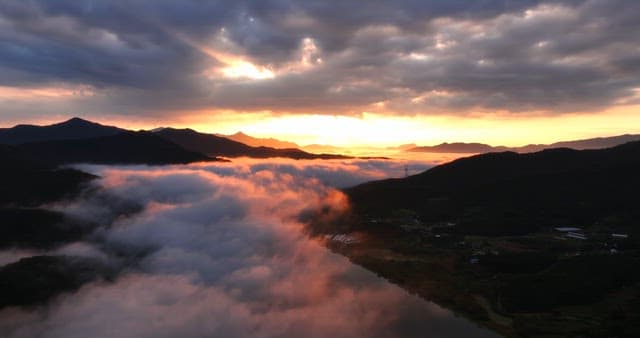 안개 낀 산과 강 위의 일출