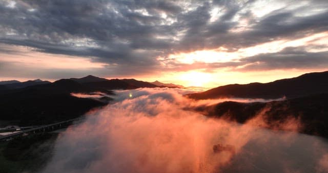 Sunrise over misty mountains and river