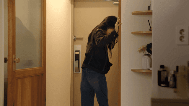 Couple at doorway with woman leaving in dark expression