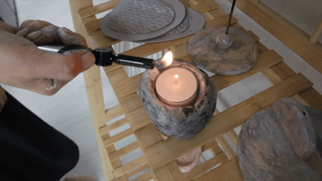 나무 선반 위에 촛불을 켜는 모습