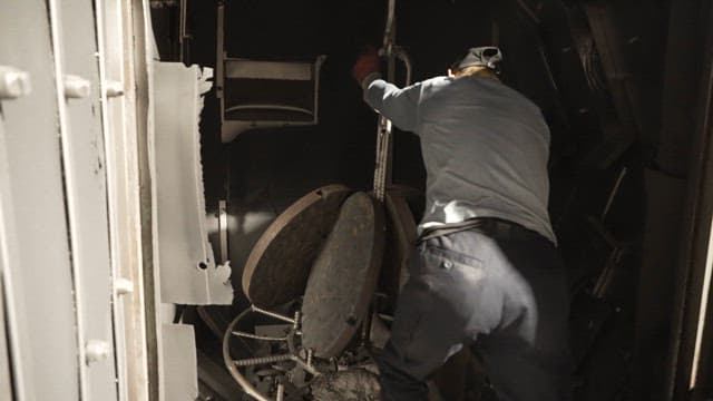 금속 부품을 컨테이너에 넣는 작업자