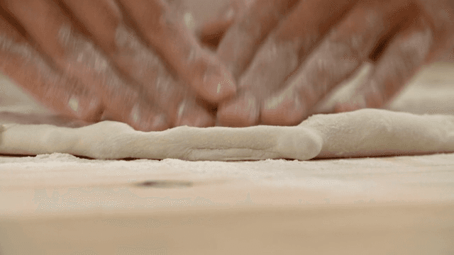 나무 도마에서 반죽을 치대는 손