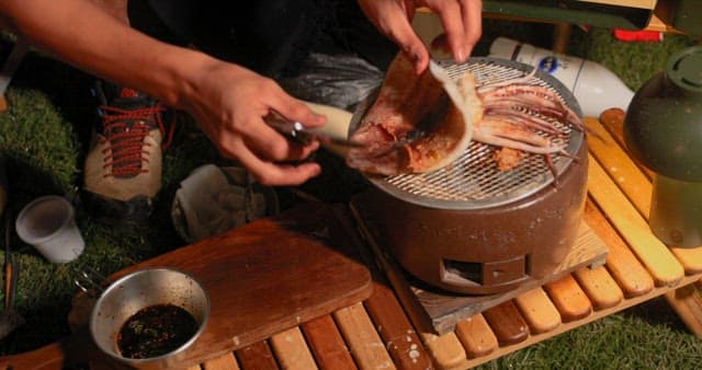 Grilling Squid on a Portable Stove Outdoors