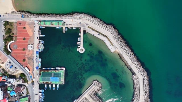 Coastal harbor with boats and breakwater