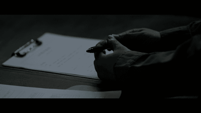 문서 위에 펜을 들고 있는 손