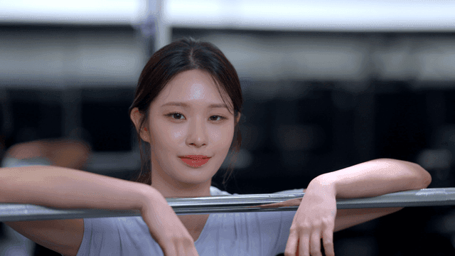 바벨에 기대어 헬스장에서 쉬는 젊은 여성