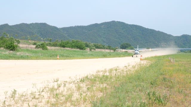 Small airplane taking off from rural airstrip