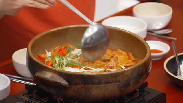 Table filled with spicy and hearty kimchi stew