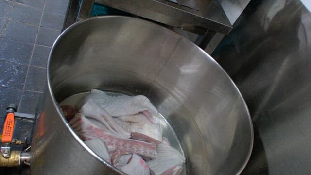 Boiling meat in a large pot with water