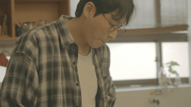 집에서 체크 셔츠를 입은 안경 쓴 남자