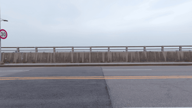 속도 제한 표지판이 있는 차량이 지나가는 도로