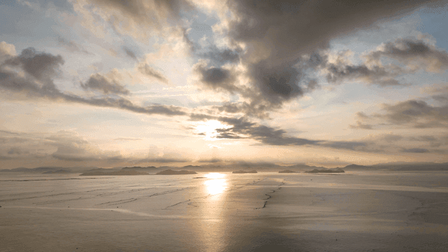 Sunset over a calm sea with distant islands